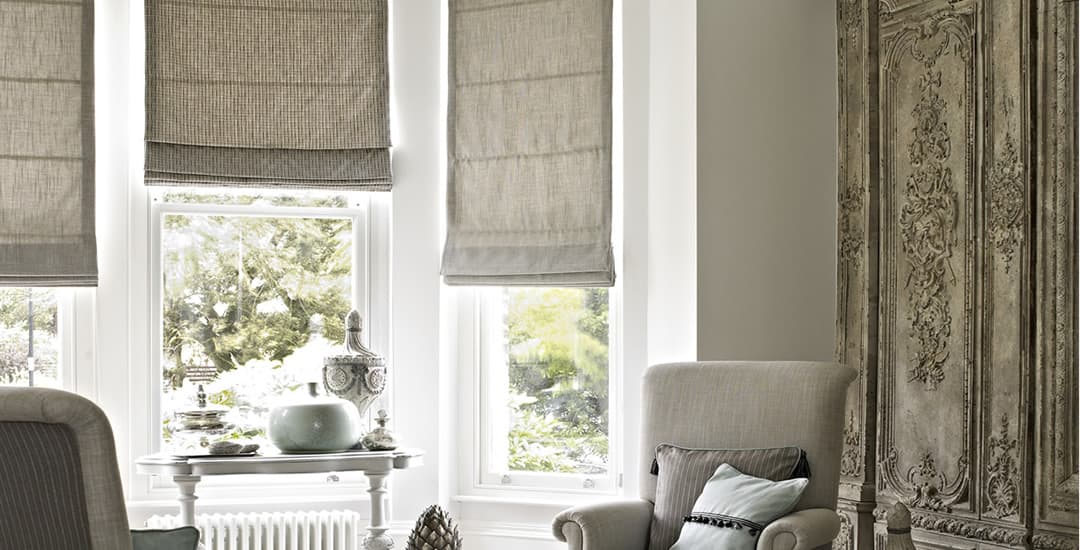 Brown roman blinds in long bay window