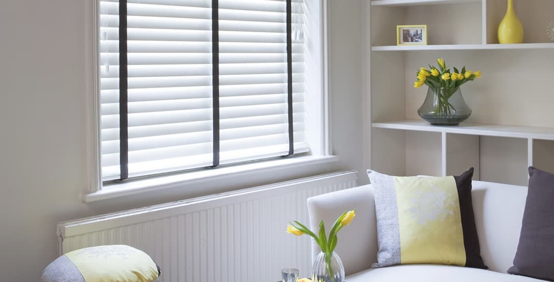 White wooden blinds with black tapes
