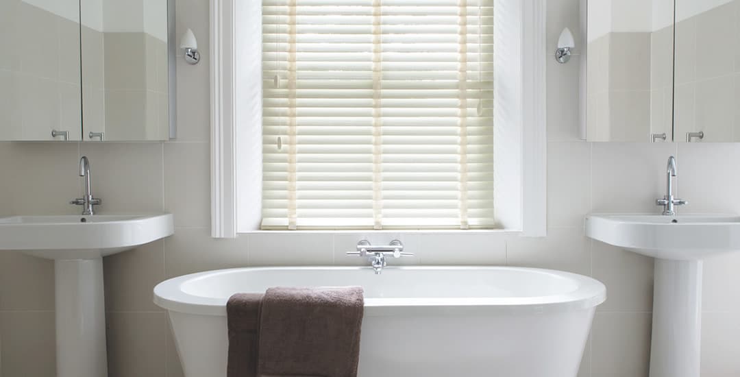 Cream faux wood blinds in white bathroom