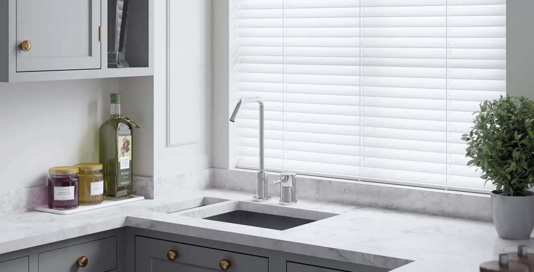 White faux wood blinds in kitchen