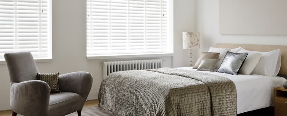 White taped faux wood blinds in bedroom