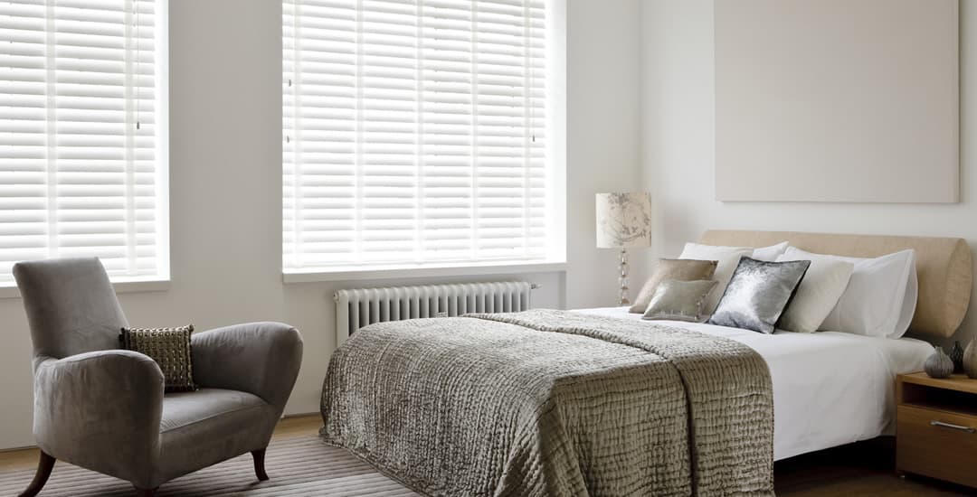 White taped faux wood blinds in bedroom
