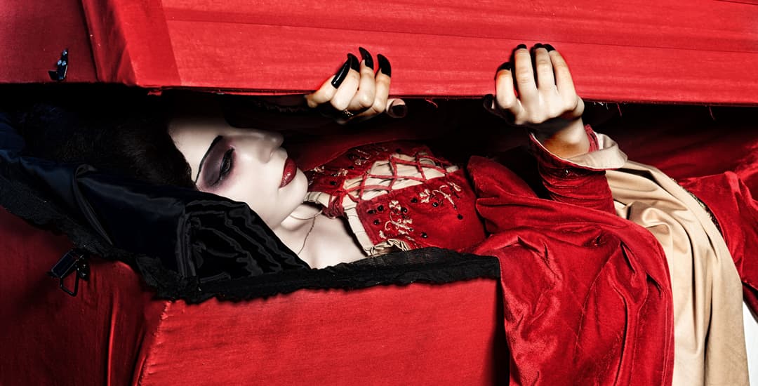 Female vampire hiding from the light in coffin