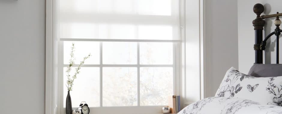 White roller blinds fitted inside window recess