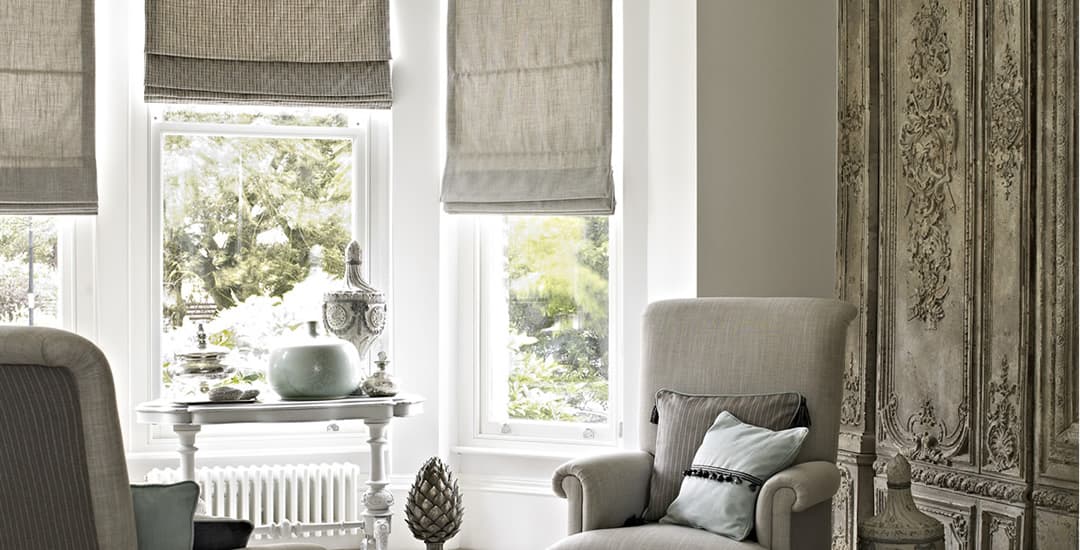 Brown roman blinds in lounge bay window