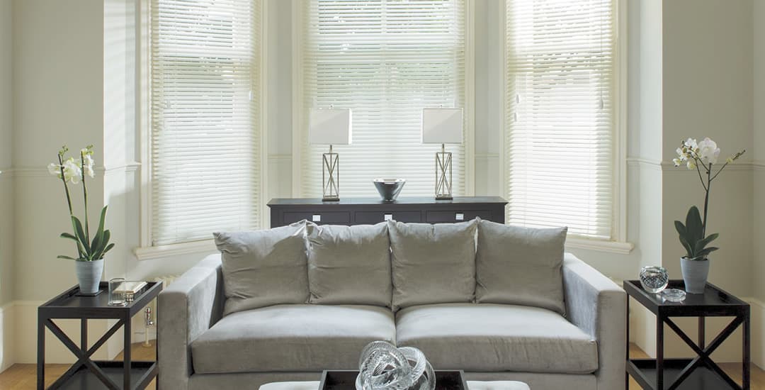 Cream venetian blinds in living room bay window