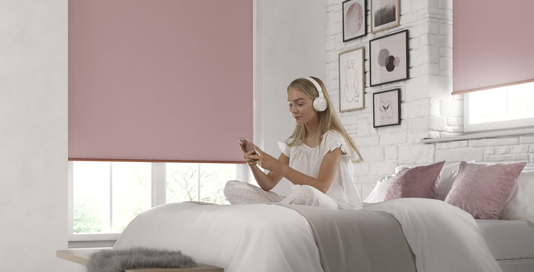 Pink blackout blinds in bedroom with woman