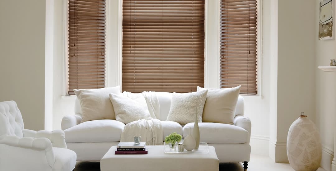 Walnut wooden blinds in living room bay window 