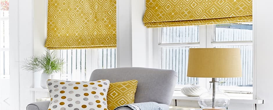 Yellow patterned roman blinds inside window recess