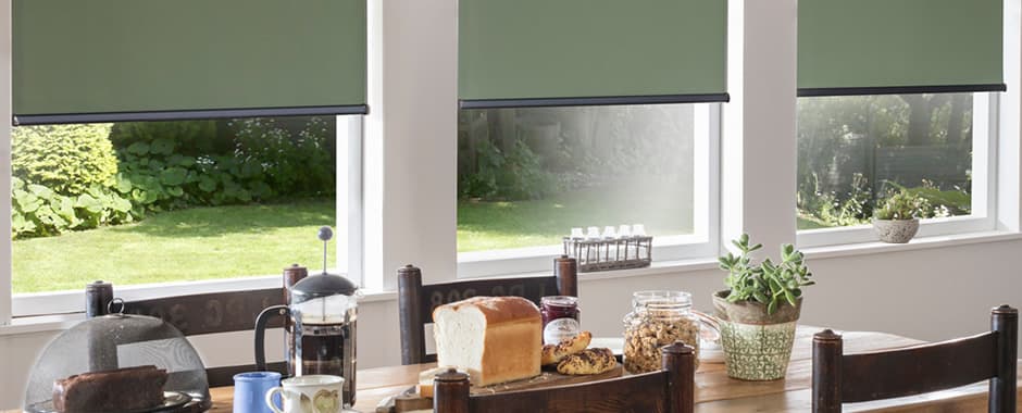 Green roller blinds in dining room