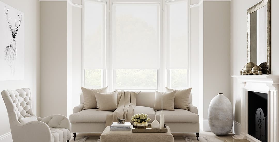 White roller blinds in living room bay window