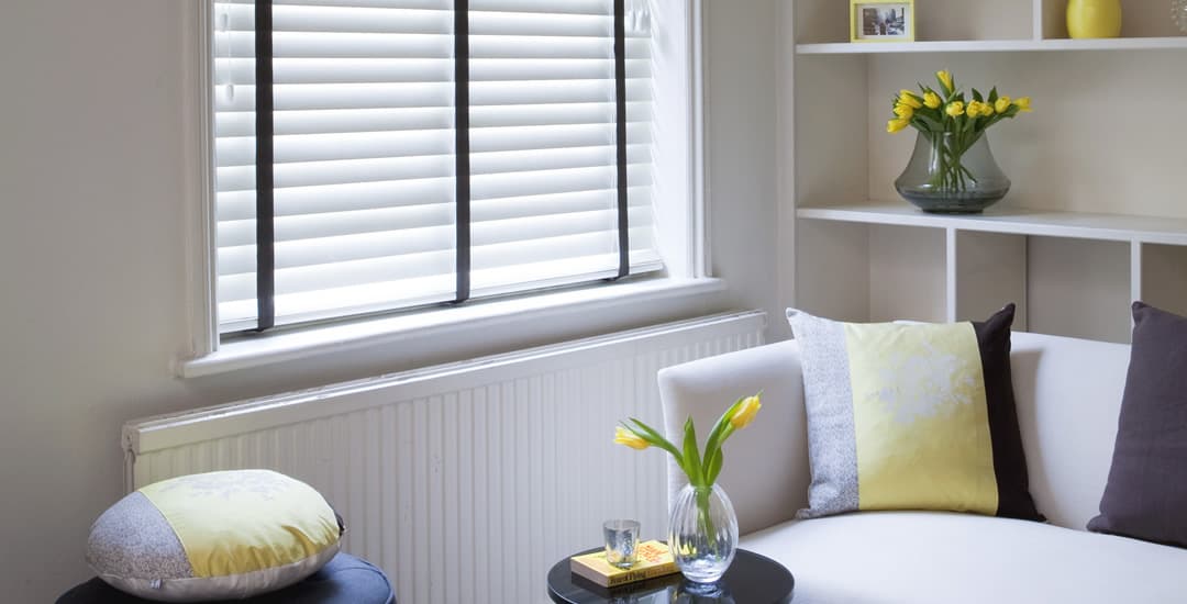 White wooden blinds with black tapes in living room