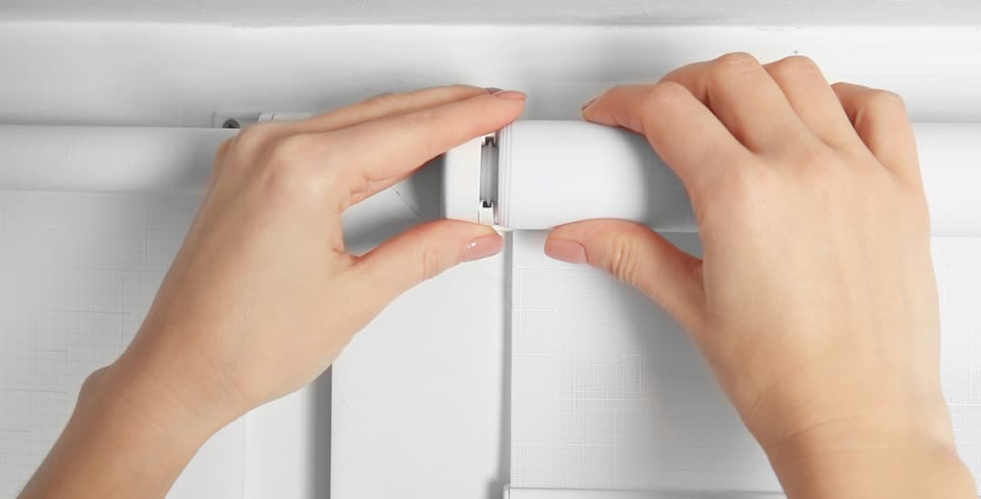 Woman installing roller blinds