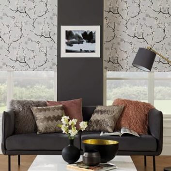 Light grey floral roller blinds in lounge with dark walls