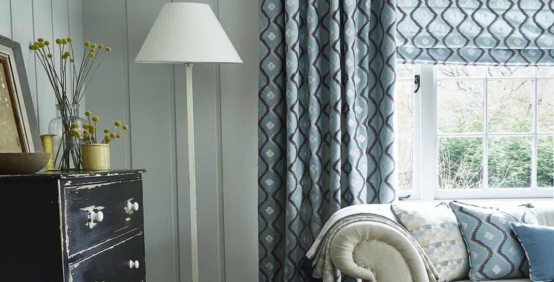 Blue patterned roman blinds and curtains in lounge