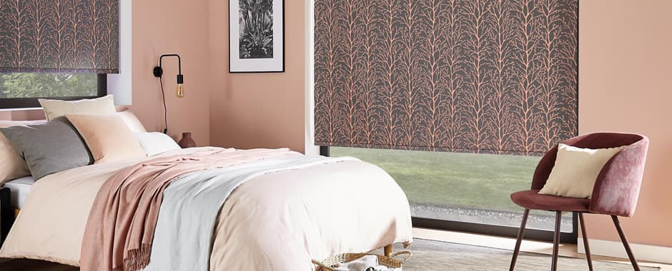 Coral patterned blackout roller blinds in bedroom