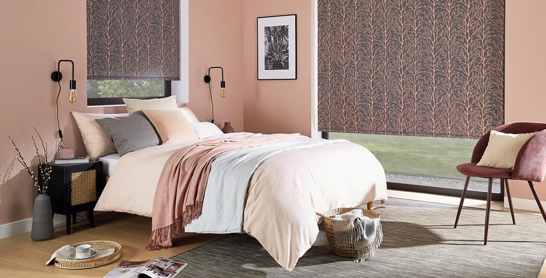 Coral patterned blackout roller blinds in bedroom