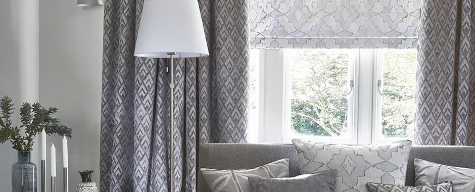 Grey patterned roman blinds and curtains in lounge