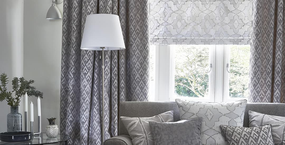 Grey patterned roman blinds and curtains in lounge