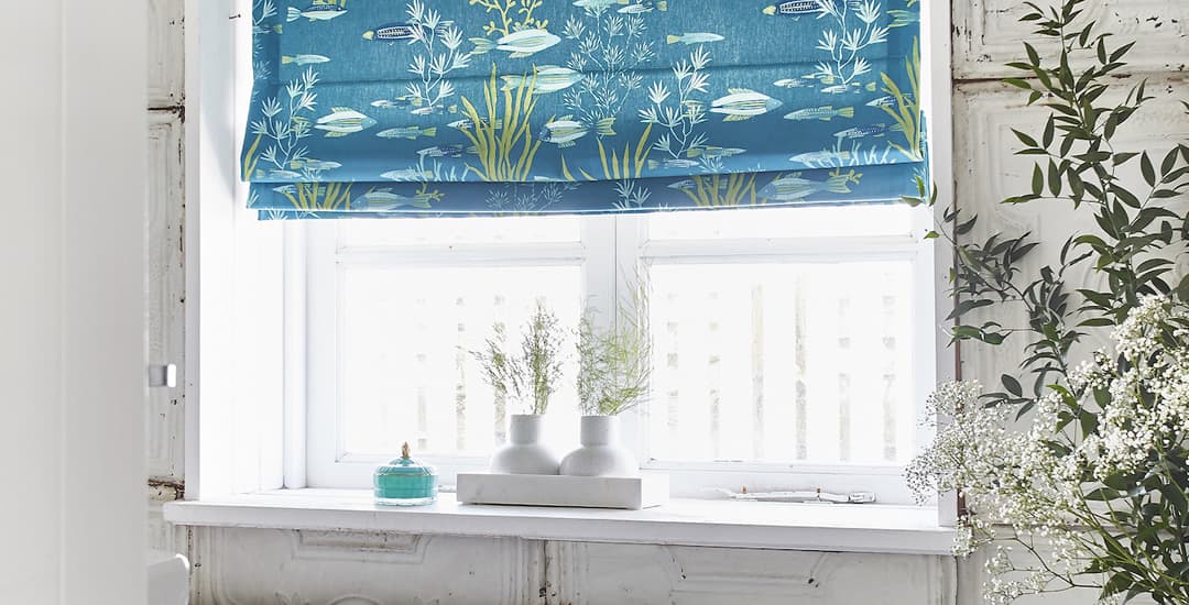 Blue fish patterned roman blinds in bathroom