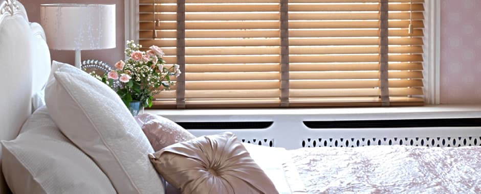 Real wooden blinds with tapes resting on the windowsill