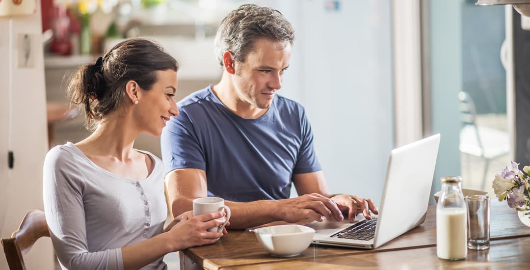 A couple ordering blinds on laptop