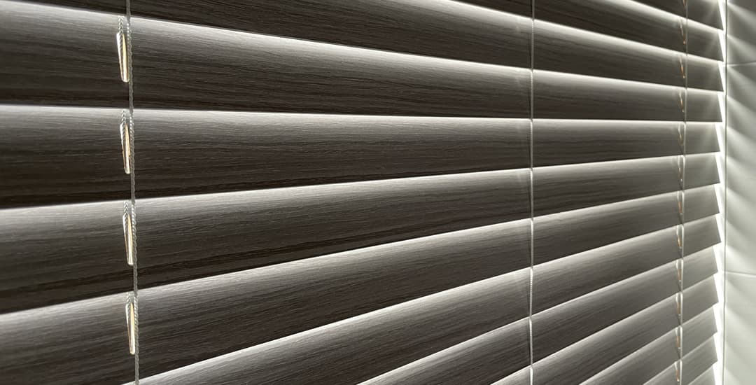 Closed wooden venetian blind showing how much light it allows in