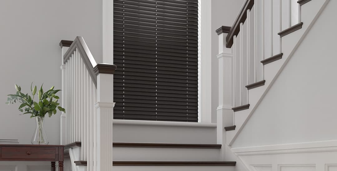 Dark real wood blinds in hallway staircase