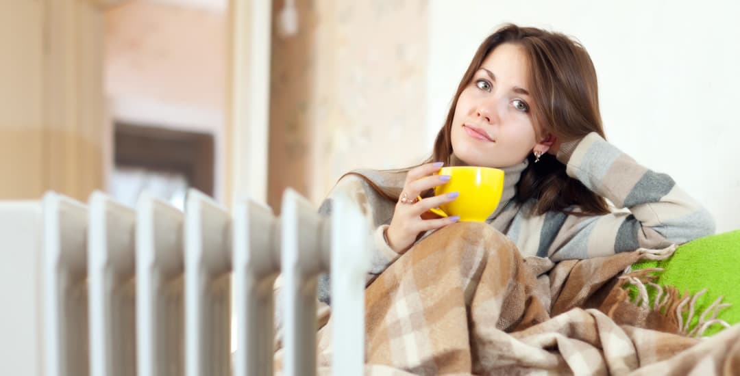 Woman at home in jumper under blanket