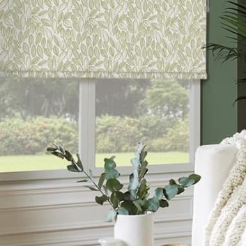 Green laurel patterned roller blinds in green living room