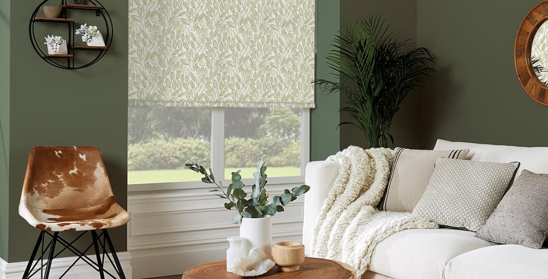 Green laurel patterned roller blinds in green living room