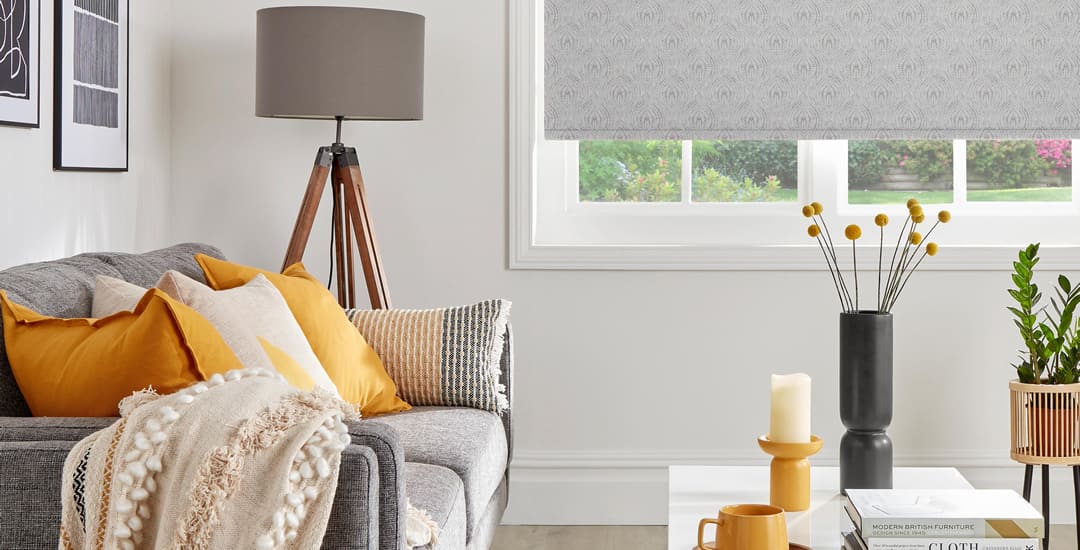 Living room with grey blind, yellow cushions and cream throw on sofa