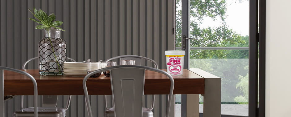 The pink stuff oxi powder in front of vertical blinds