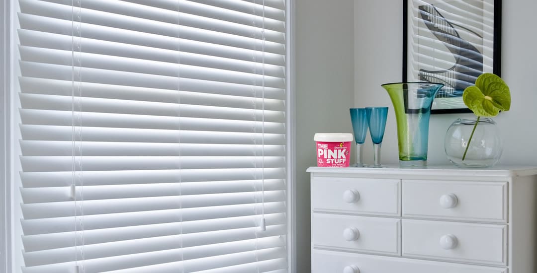 White wooden blinds with the pink stuff