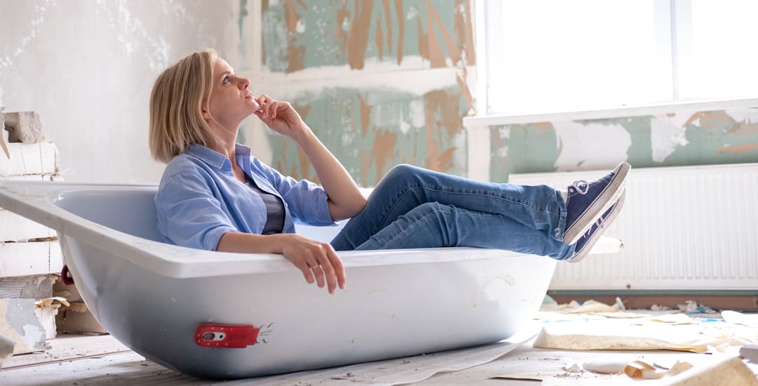 Woman sat in undecorated bathroom