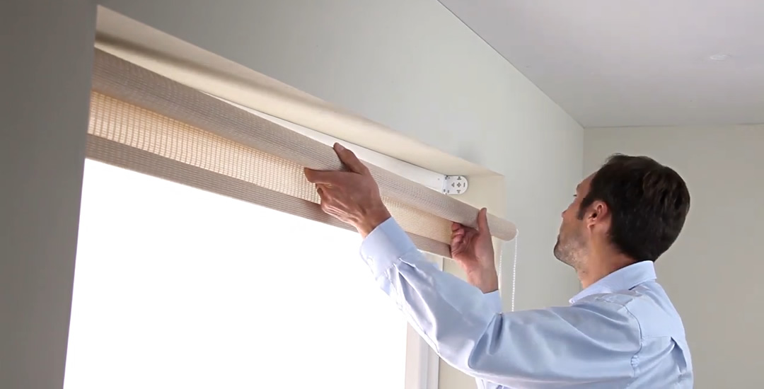 Man locating a roller blind into its brackets