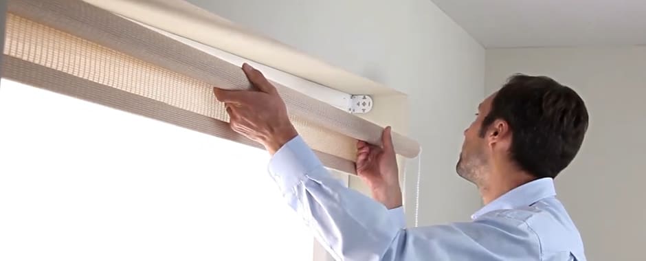 Man locating a roller blind into its brackets