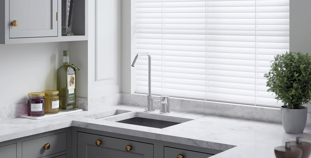 White pvc faux wood venetian blinds in kitchen window