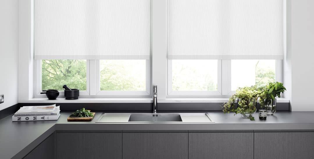 White roller blinds at a modern grey kitchen window