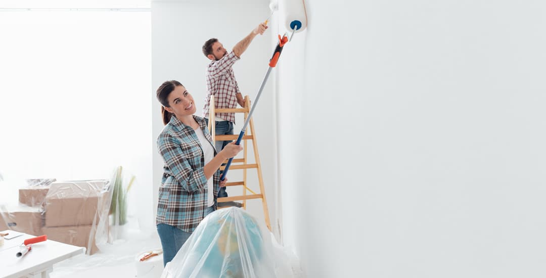 Young couple painting a wall