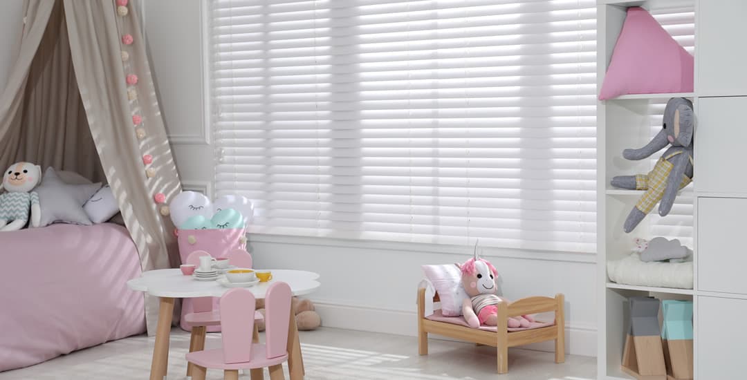 Cute pink kids bedroom with white faux wood venetian blinds