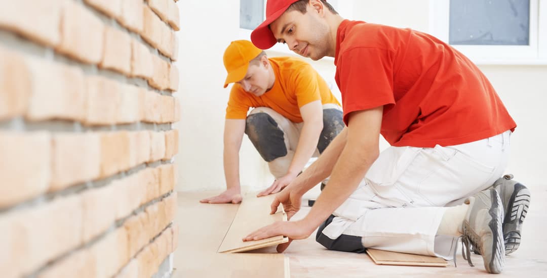 Two professionals laying parquet wooden flooring