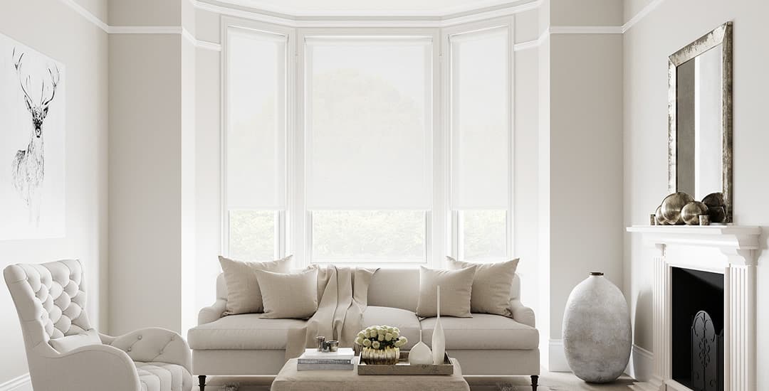 White roller blinds in cosy living room bay window