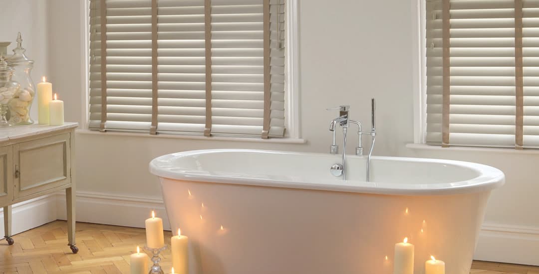 Beige faux wood blinds in bathroom with candles