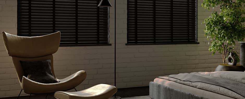 Black wood venetian blinds in bedroom at night