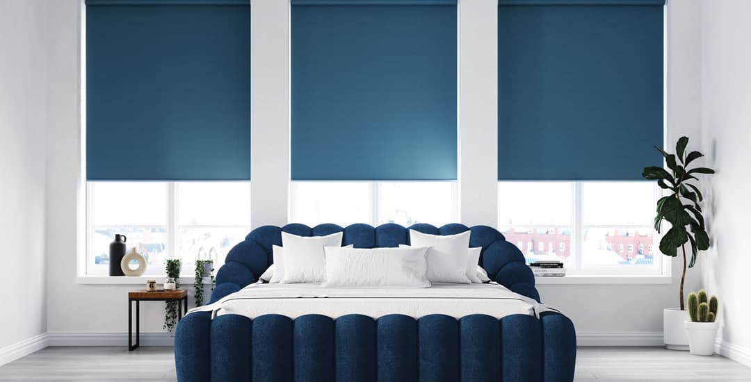 Blue thermal blackout roller blinds in bedroom