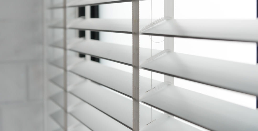 White faux wood blinds with tapes closeup
