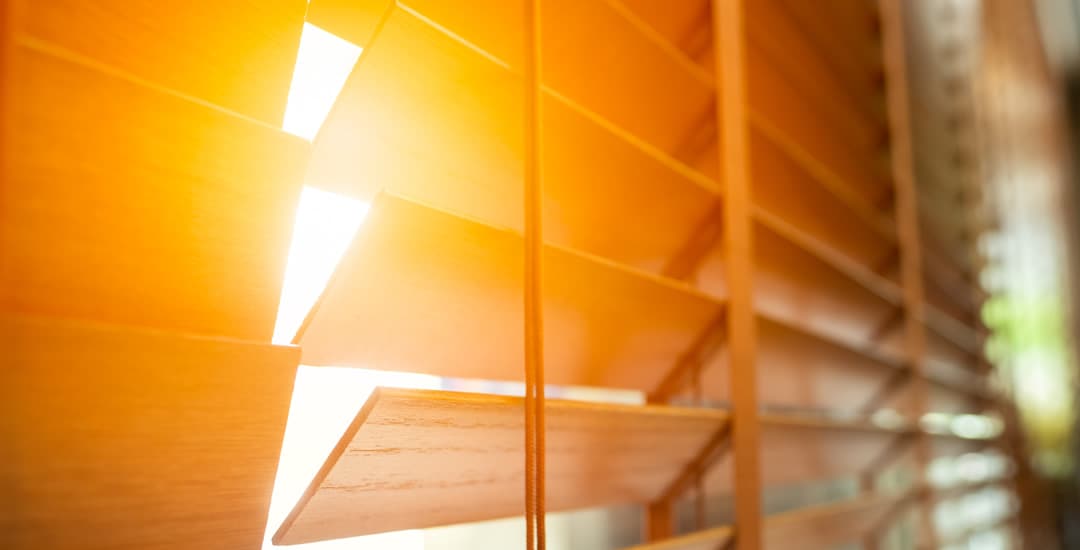 Closeup of wooden blinds in early morning sunlight