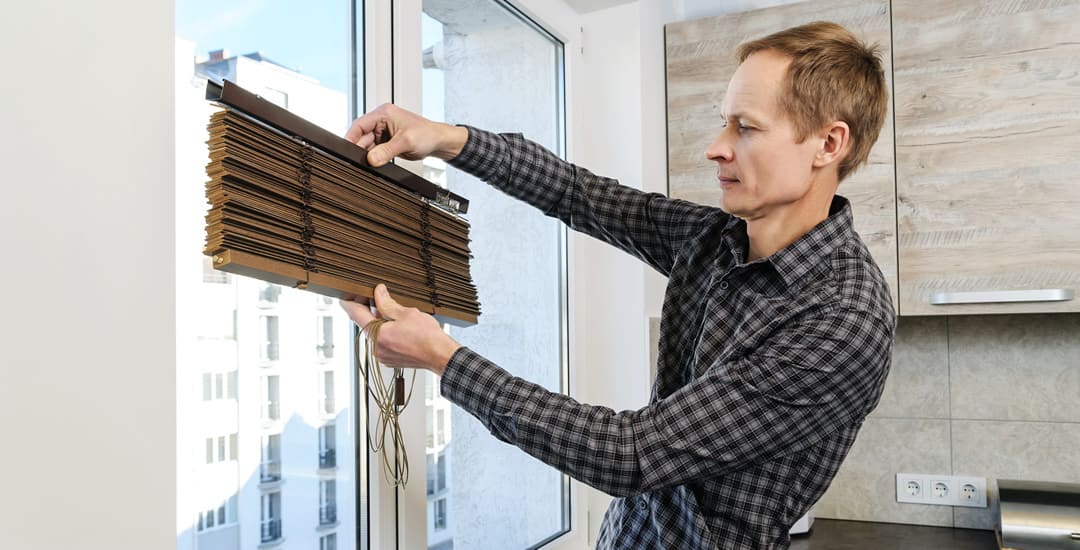 Man holding wooden blind ready to install it