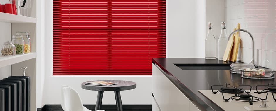 Red Venetian blinds in modern kitchen